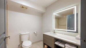 Moderni kylpyhuone, jossa on wc, pesuallas ja allaskaappi.