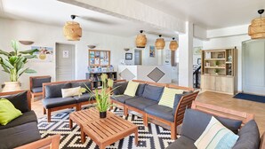 A spacious living area with sofas, a coffee table, and hanging wicker lamps. - Résidence Odalys La Palmeraie (Grimaud)