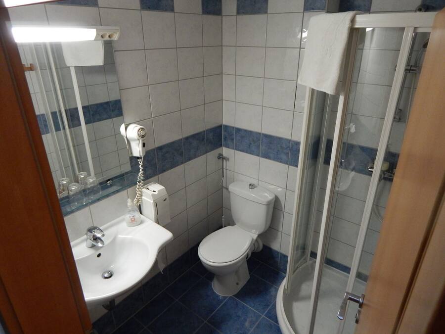 A bathroom with a sink, toilet, and glass shower enclosure.