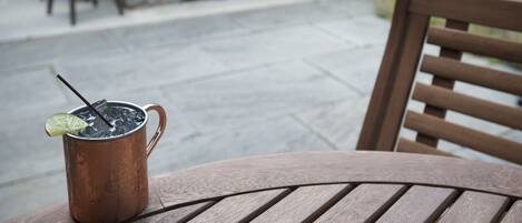 A copper mug with a straw and lime on a wooden table.