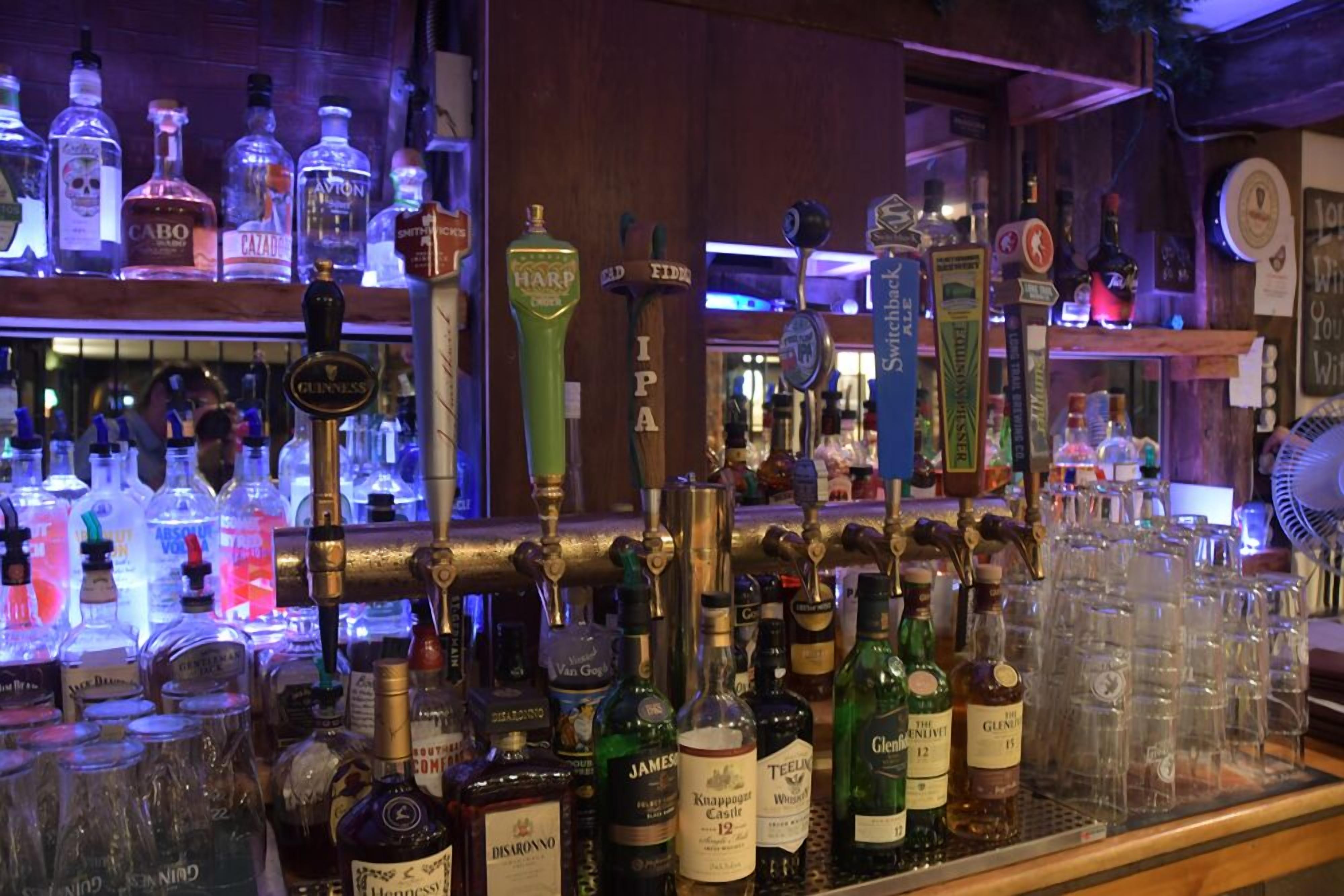 A bar with various liquor bottles and a selection of glasses.