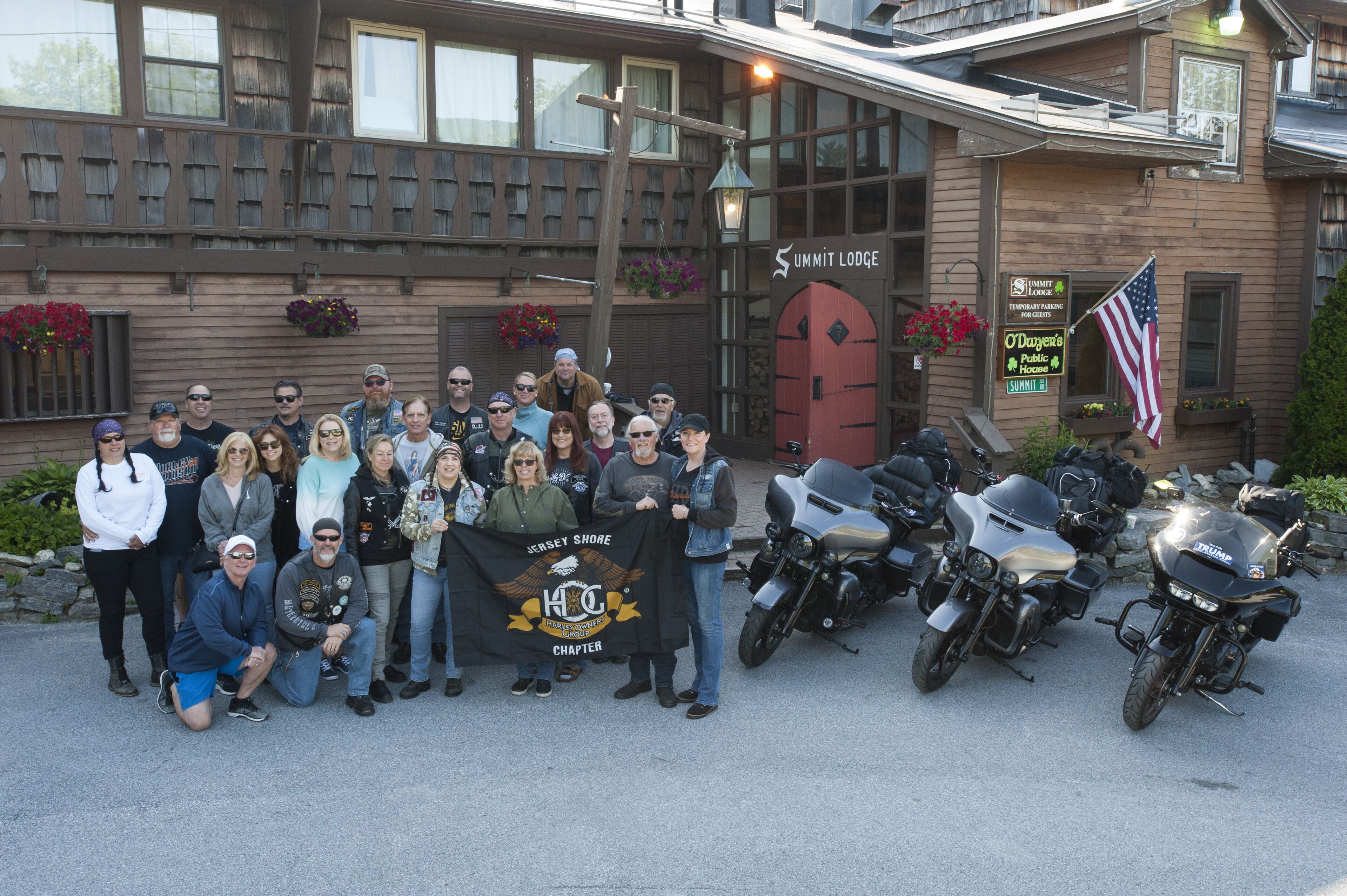 Un grupo de personas posando frente a un edificio con un letrero que dice "Summit Lodge".