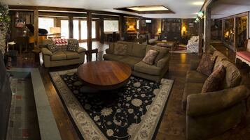 A cozy living room with a large round coffee table, two sofas, and a fireplace.