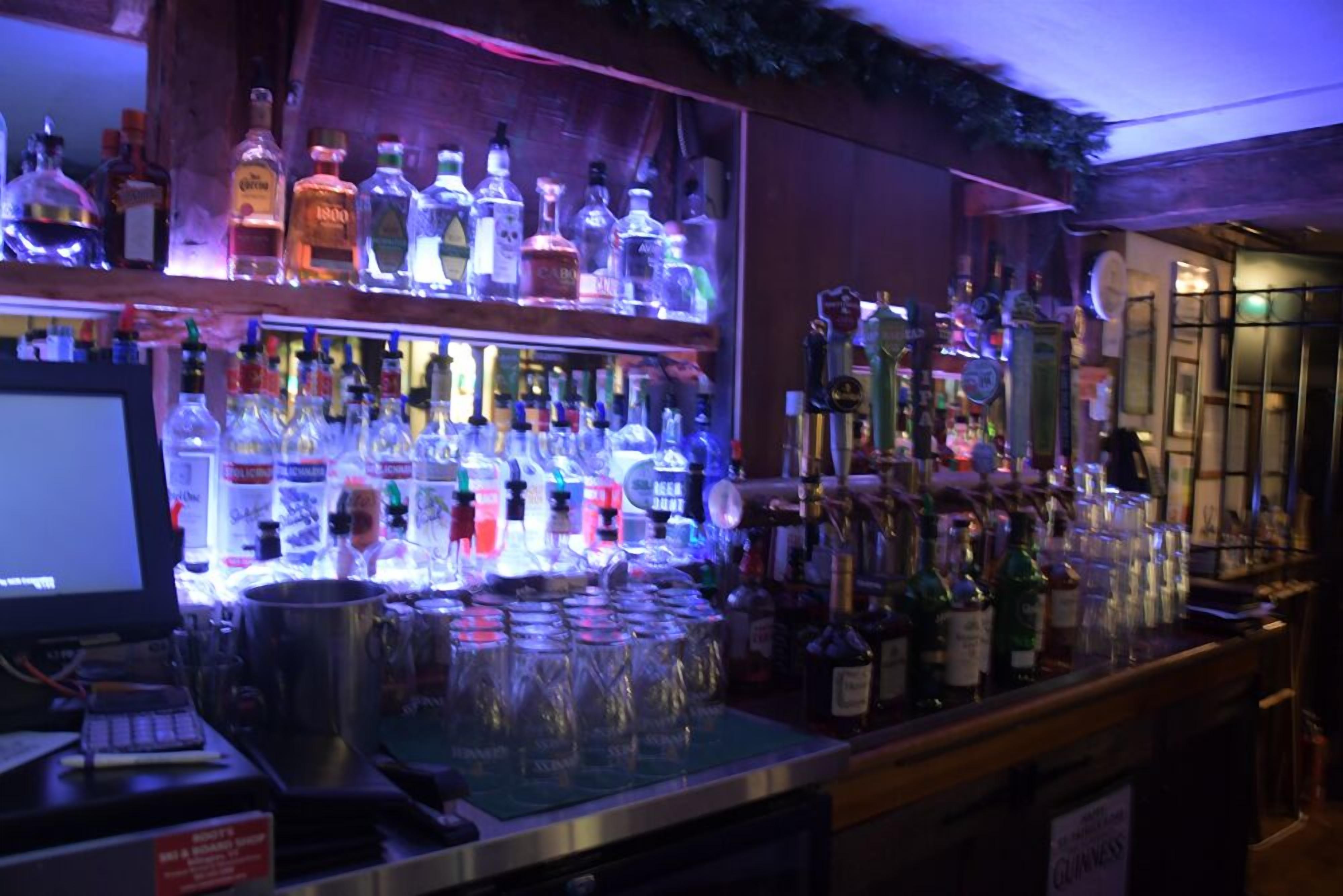 A bar area with shelves of liquor bottles and glasses.