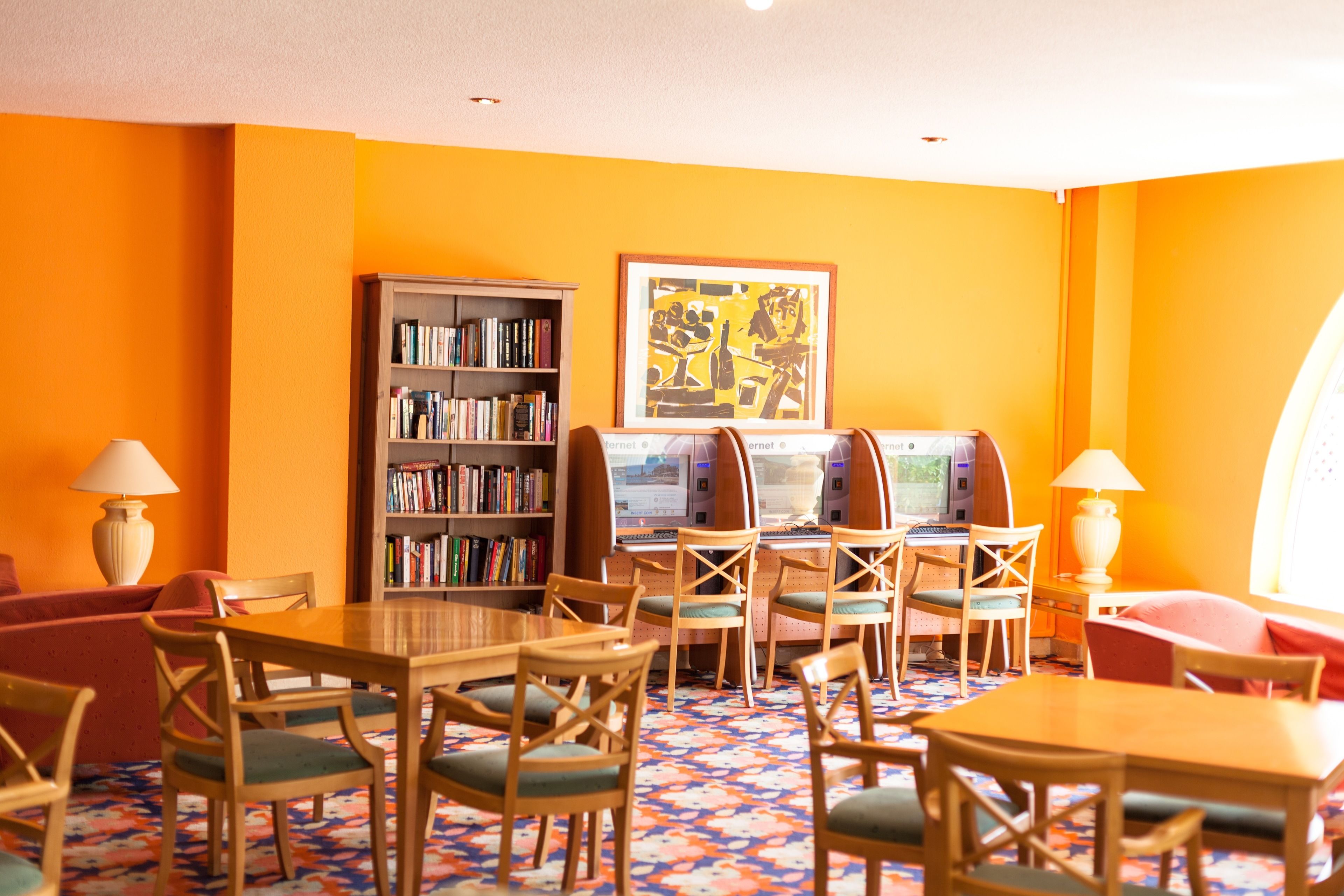 Een bibliotheek met boekenplanken, een computerwerkplek en zitgedeeltes.
