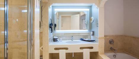 Un baño moderno con ducha de vidrio, un espejo grande y una bañera.