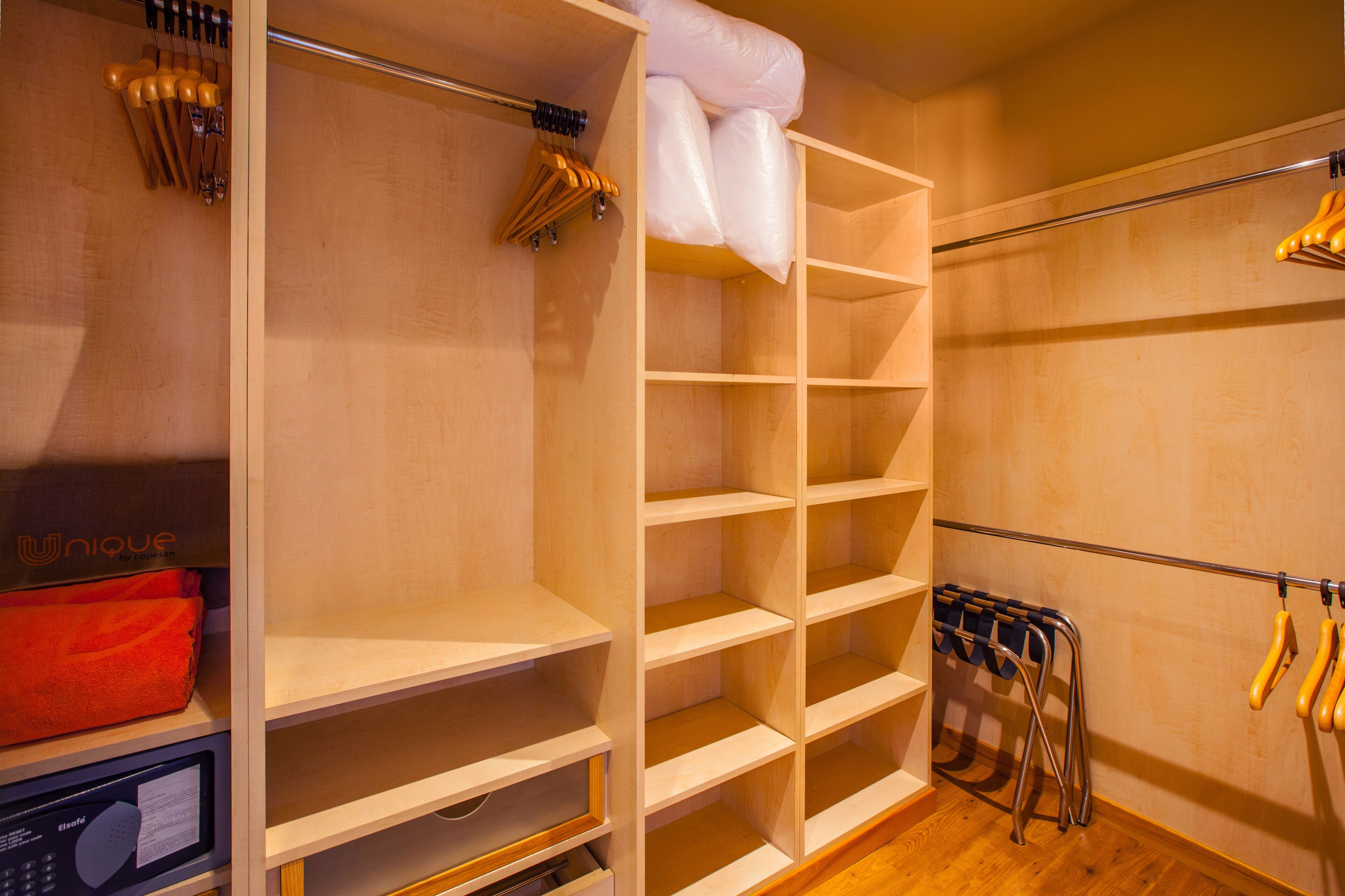 A closet with open shelves, a hanging rack, and a microwave.