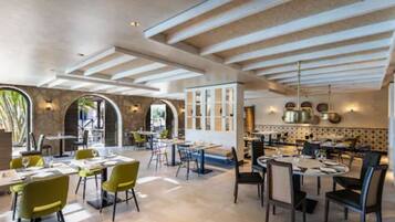 A spacious restaurant with high ceilings, natural light, and a mix of seating arrangements.