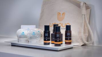 Eine Präsentation von Corailium Körperpflegeprodukten, darunter Lotion, Duschgel und Körperlotion, mit einer beigen Einkaufstasche im Hintergrund.