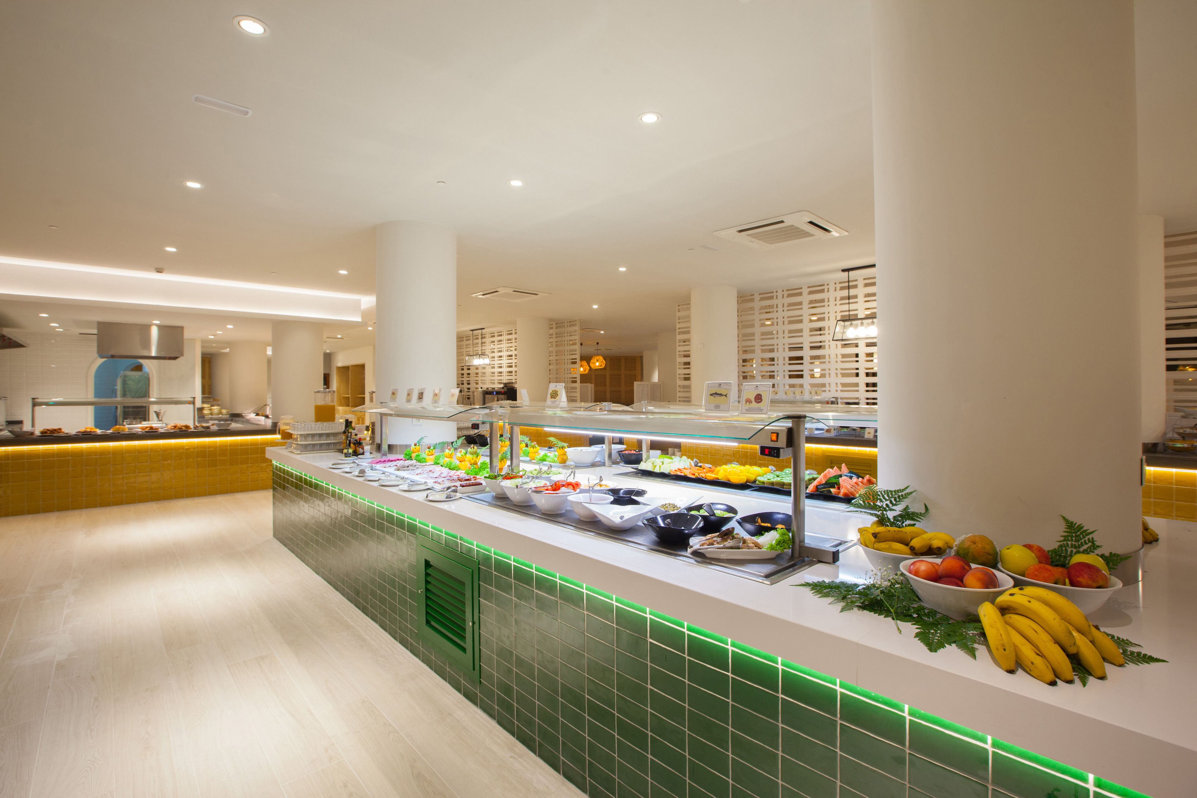 A buffet area with various food options and a green-lit counter.