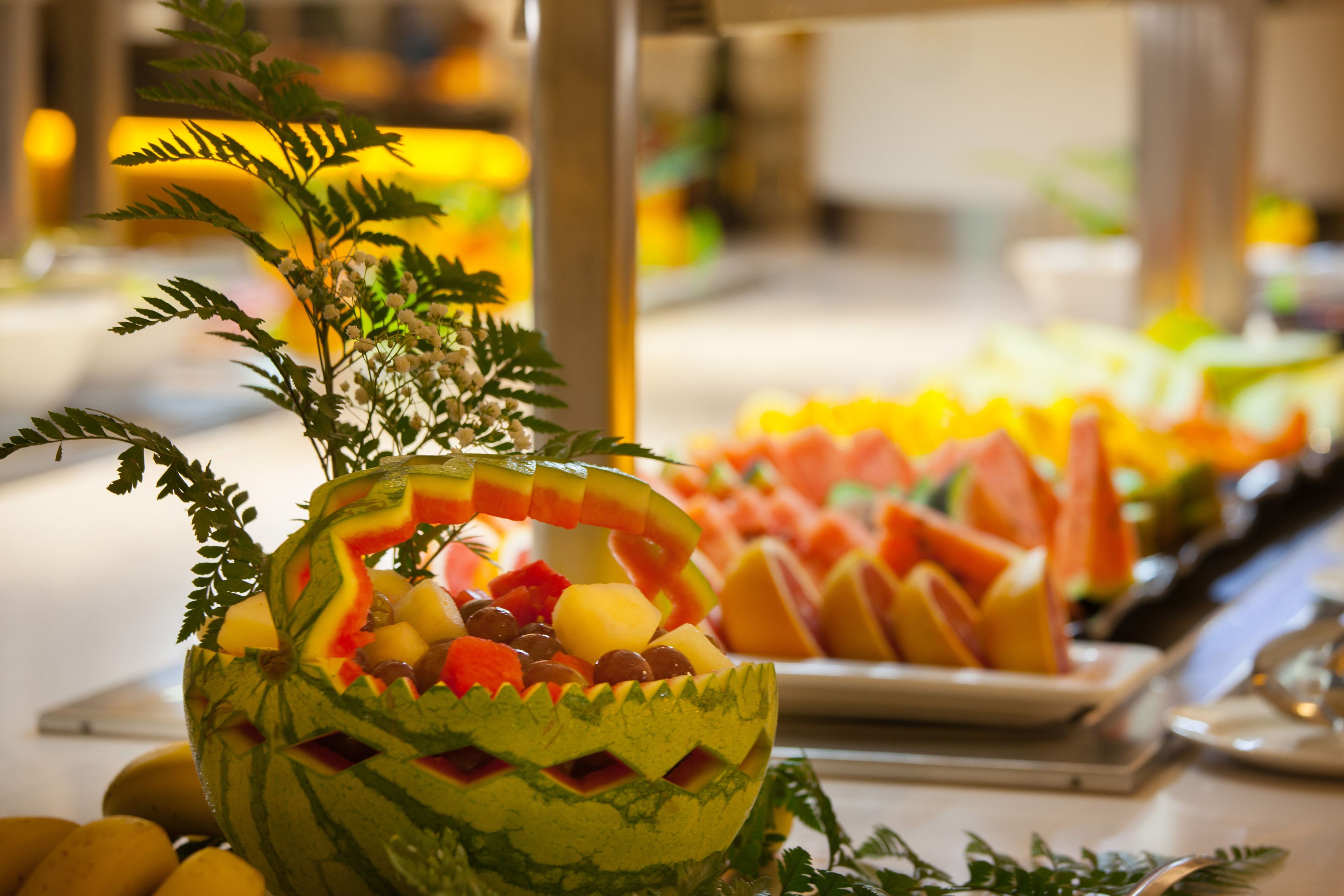 A fruit display with a carved watermelon centerpiece.