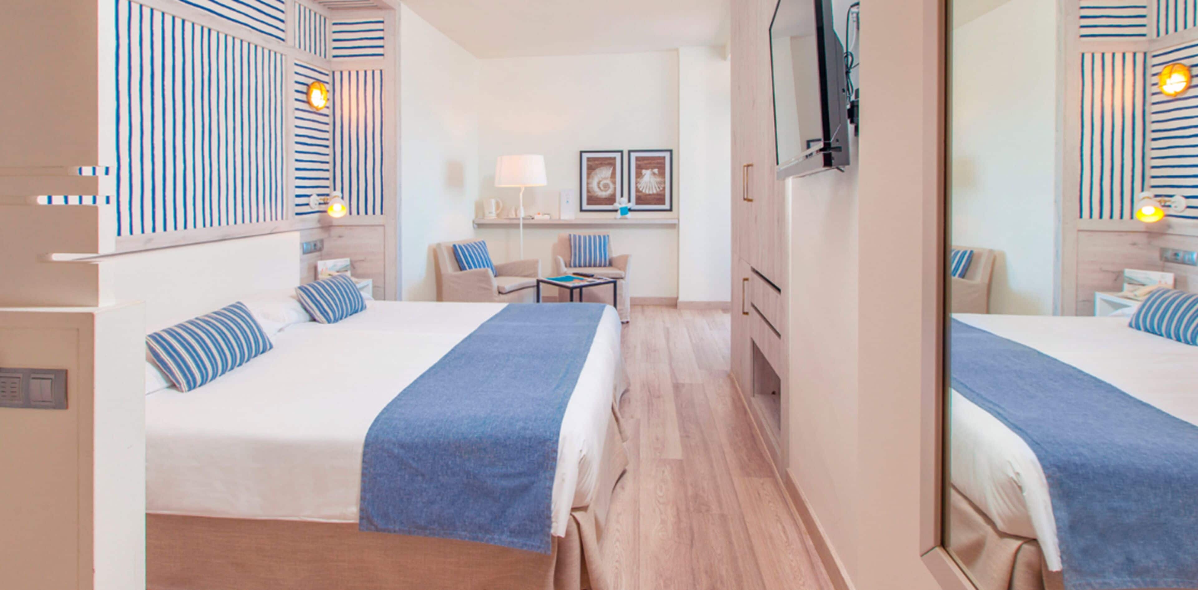 Een hotelkamer met twee bedden, een bureau, stoelen, een televisie en een spiegel.