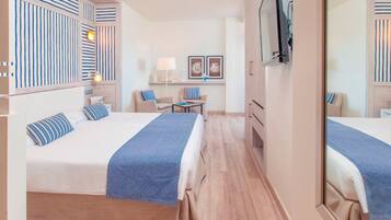 Een hotelkamer met twee bedden, een bureau, stoelen, een televisie en een spiegel.