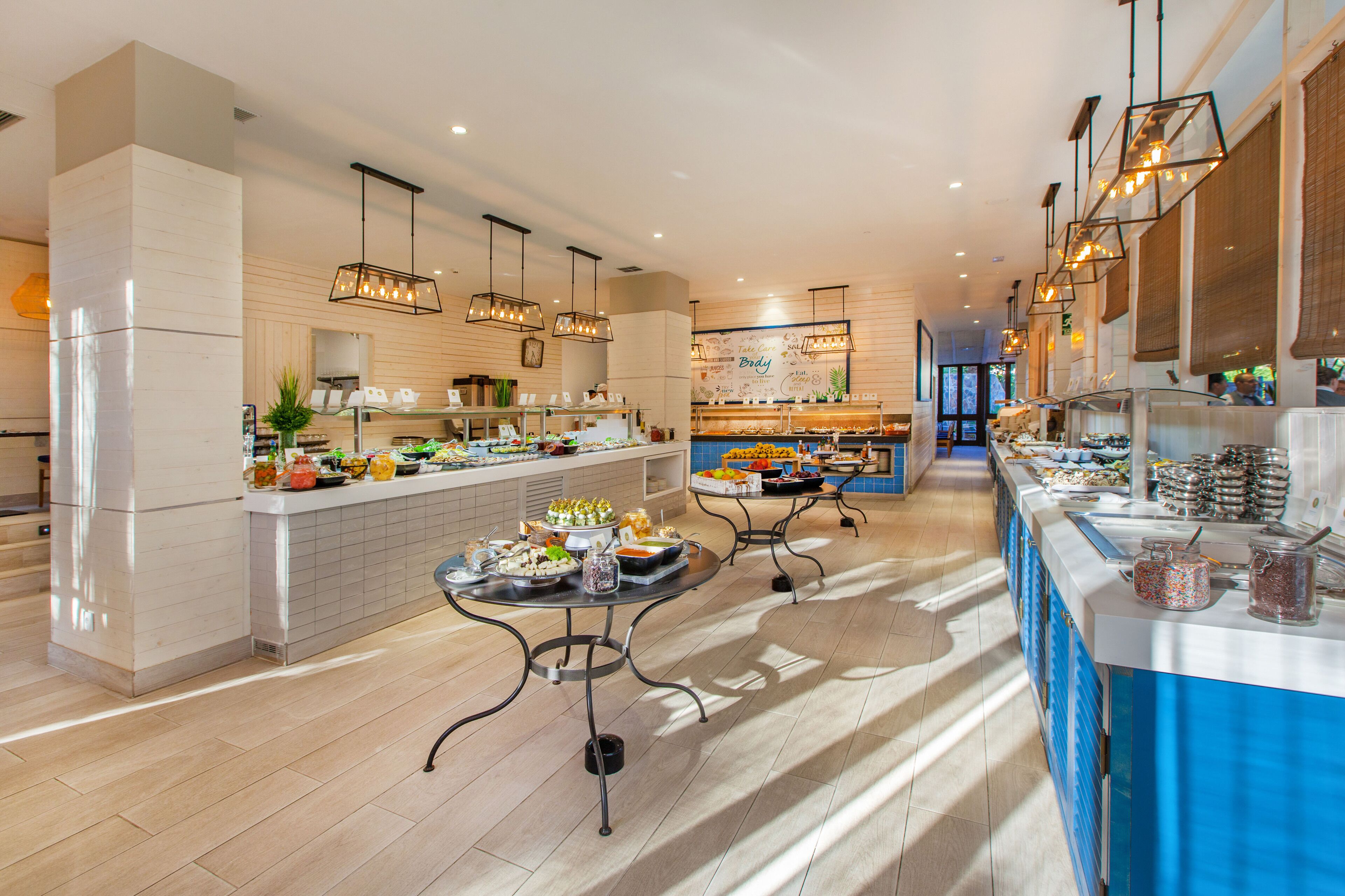 A modern kitchen with a central island, a buffet setup, and a bar area.