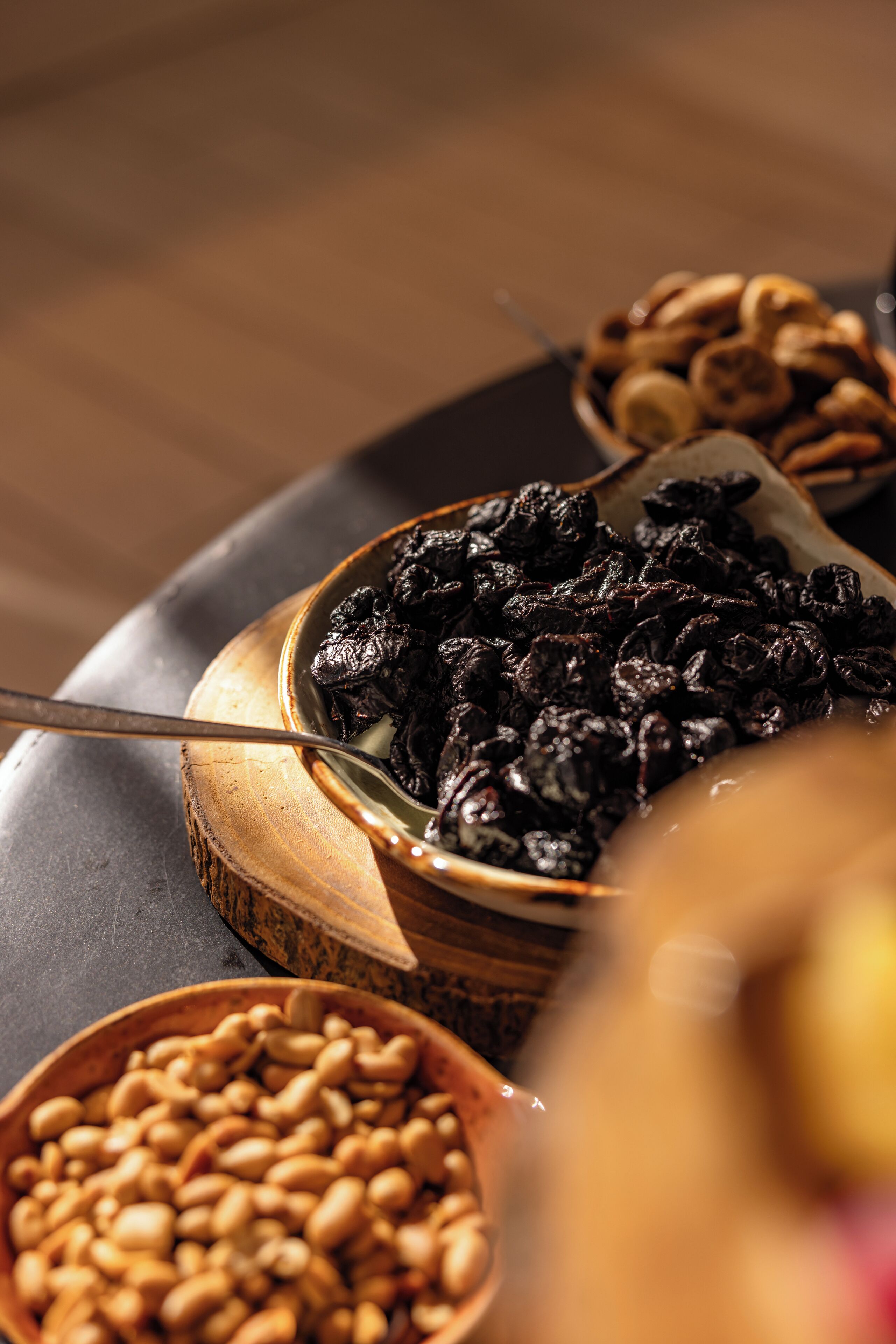 Une variété de fruits secs et de noix disposés sur une planche en bois.