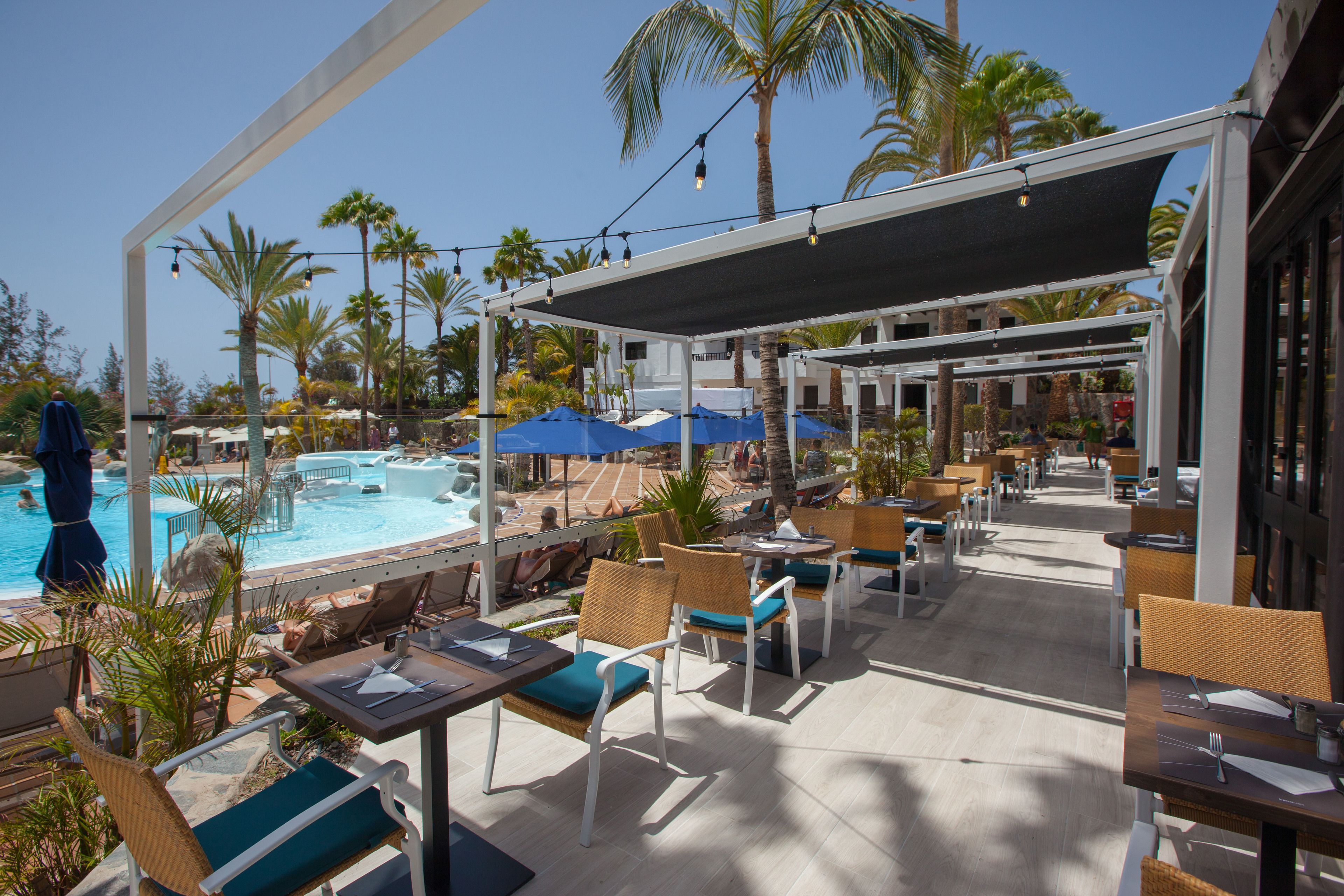 A poolside area with outdoor seating and a covered patio.