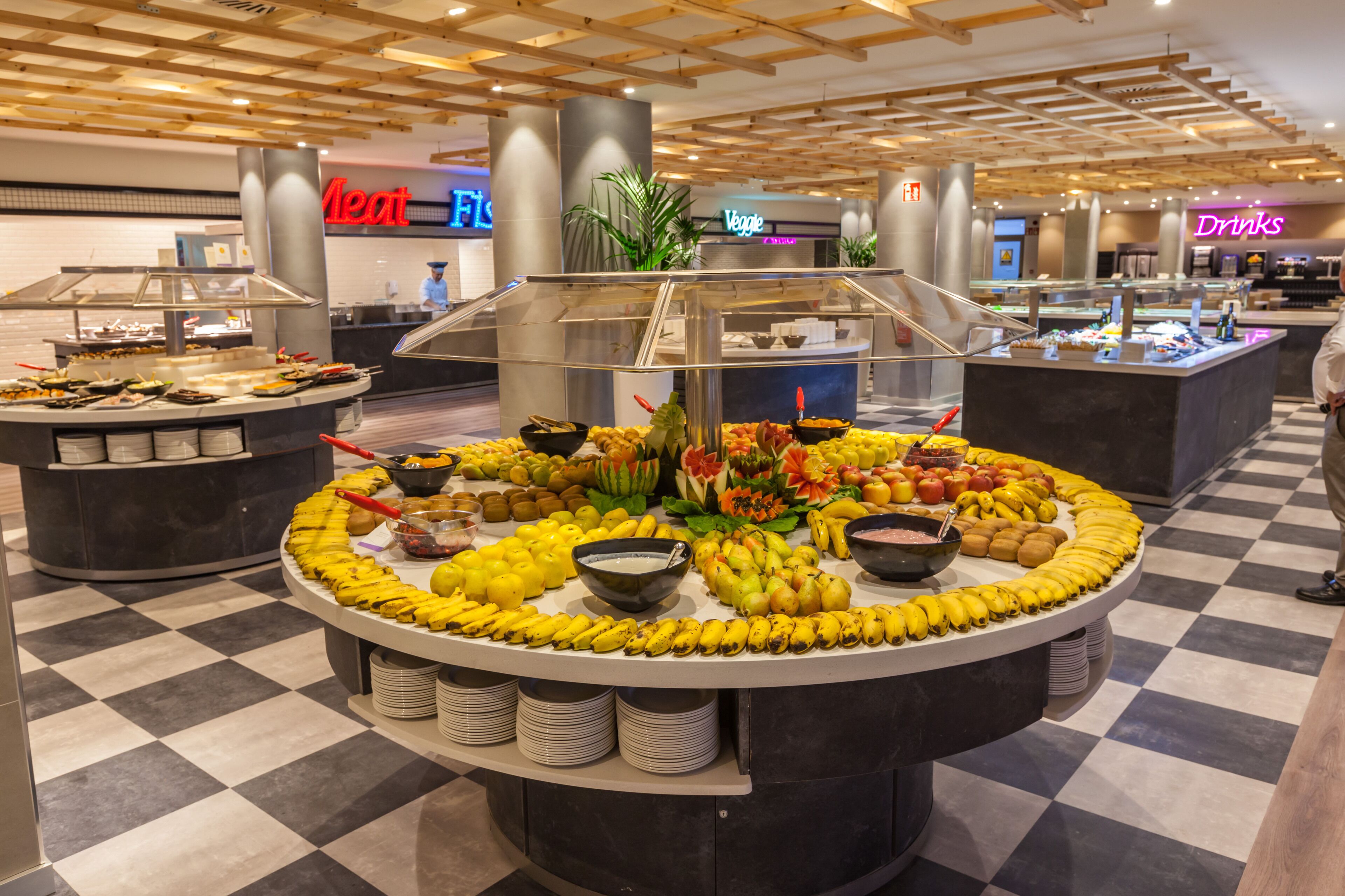 A buffet area with various food items and a 'Meat' sign in the background.