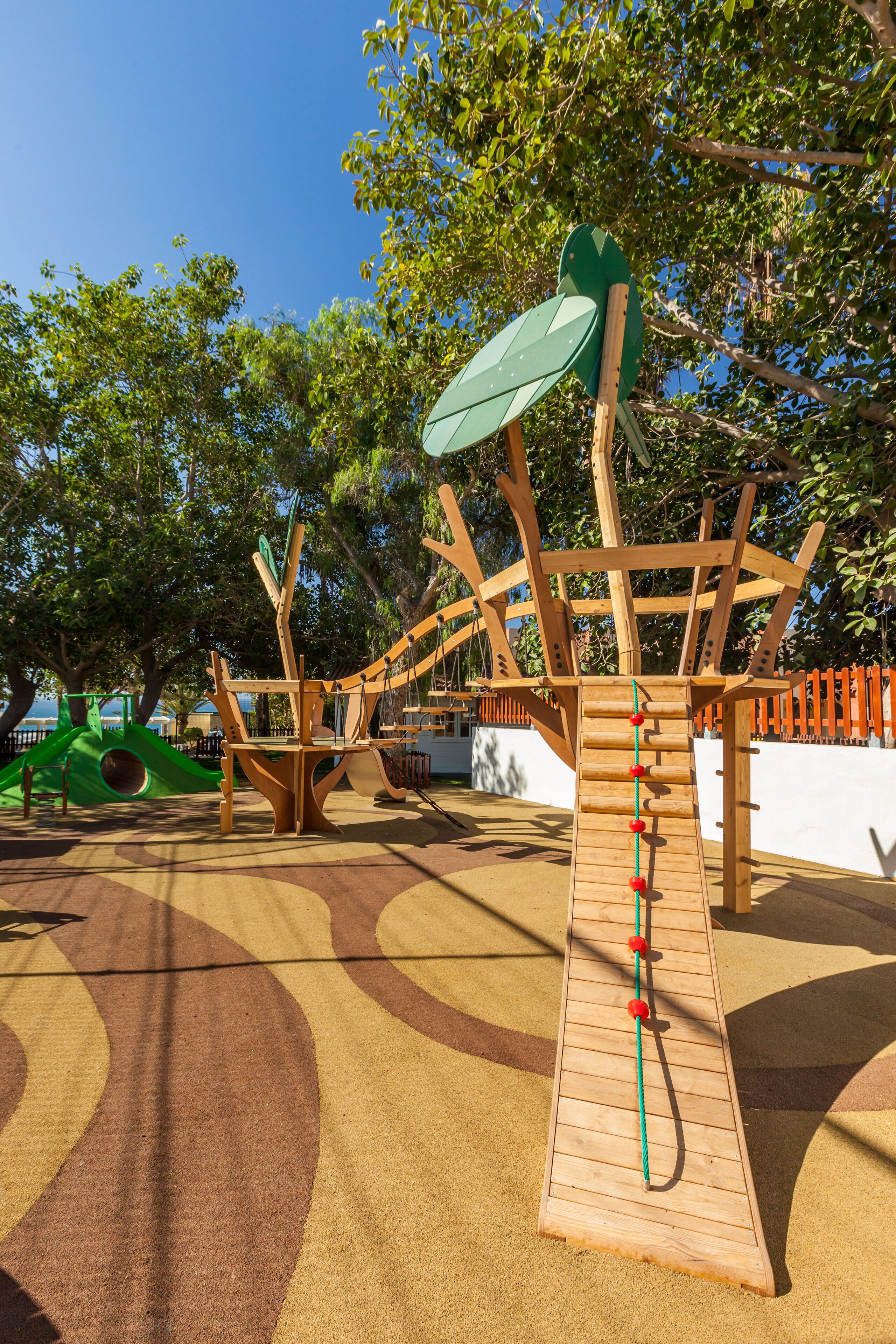 A playground with a climbing structure and a slide.