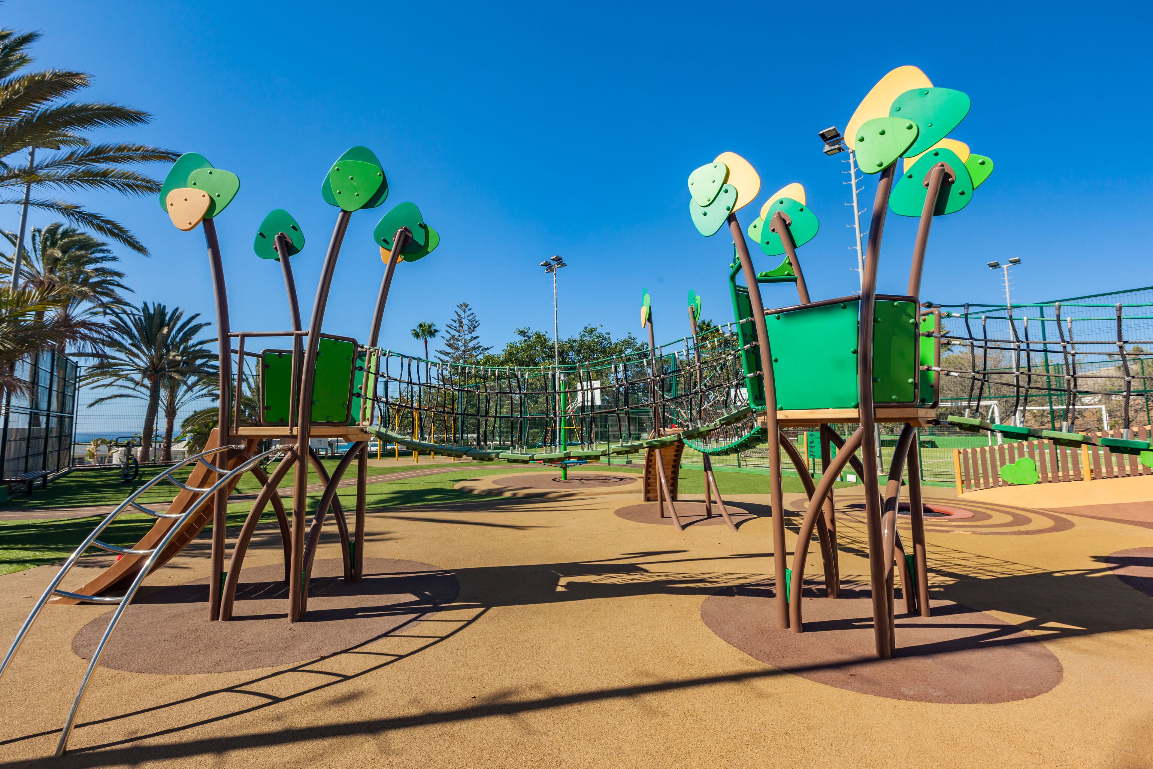 Un parque infantil con estructuras para escalar y un tobogán.