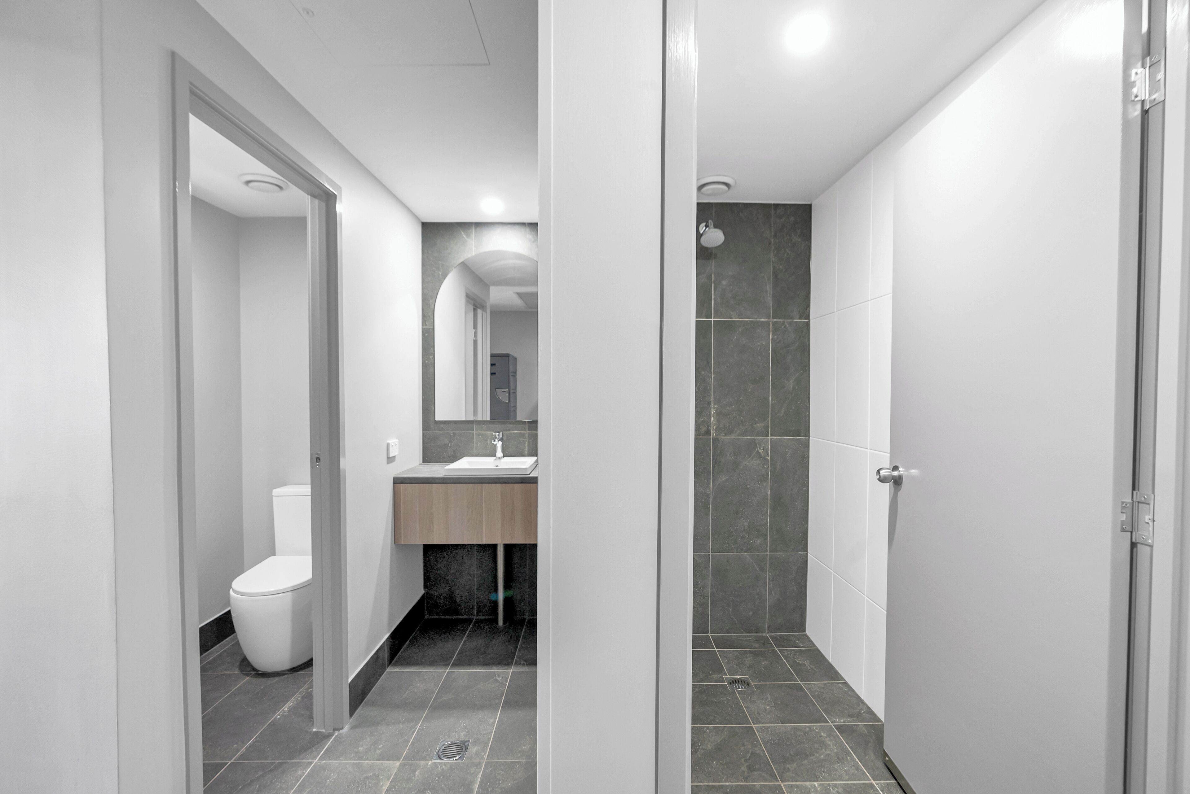 A modern bathroom with a toilet, sink, and shower area.