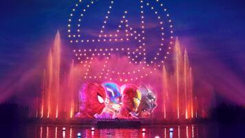 A fountain with water jets and a large illuminated arch.