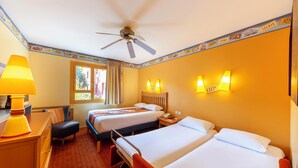 A hotel room with two beds, a desk, a chair, a ceiling fan, and two wall-mounted lamps. - Disney Hotel Santa Fe (Coupvray)