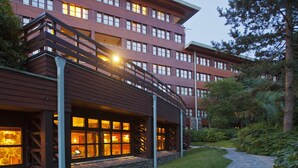 A multi-story hotel with a stone pathway leading to the entrance. - Disney Sequoia Lodge (Coupvray)