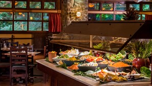 A buffet with various food items and a stone pillar. - Disney Sequoia Lodge (Coupvray)