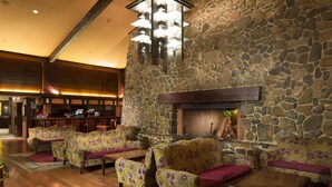 Un vestíbulo con pared de piedra, muebles de madera y chimenea.