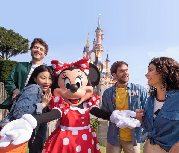 A group of people with a character in front of a castle-like structure.