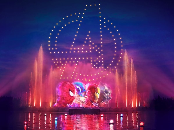 Una fuente con chorros de agua y un arco iluminado grande.