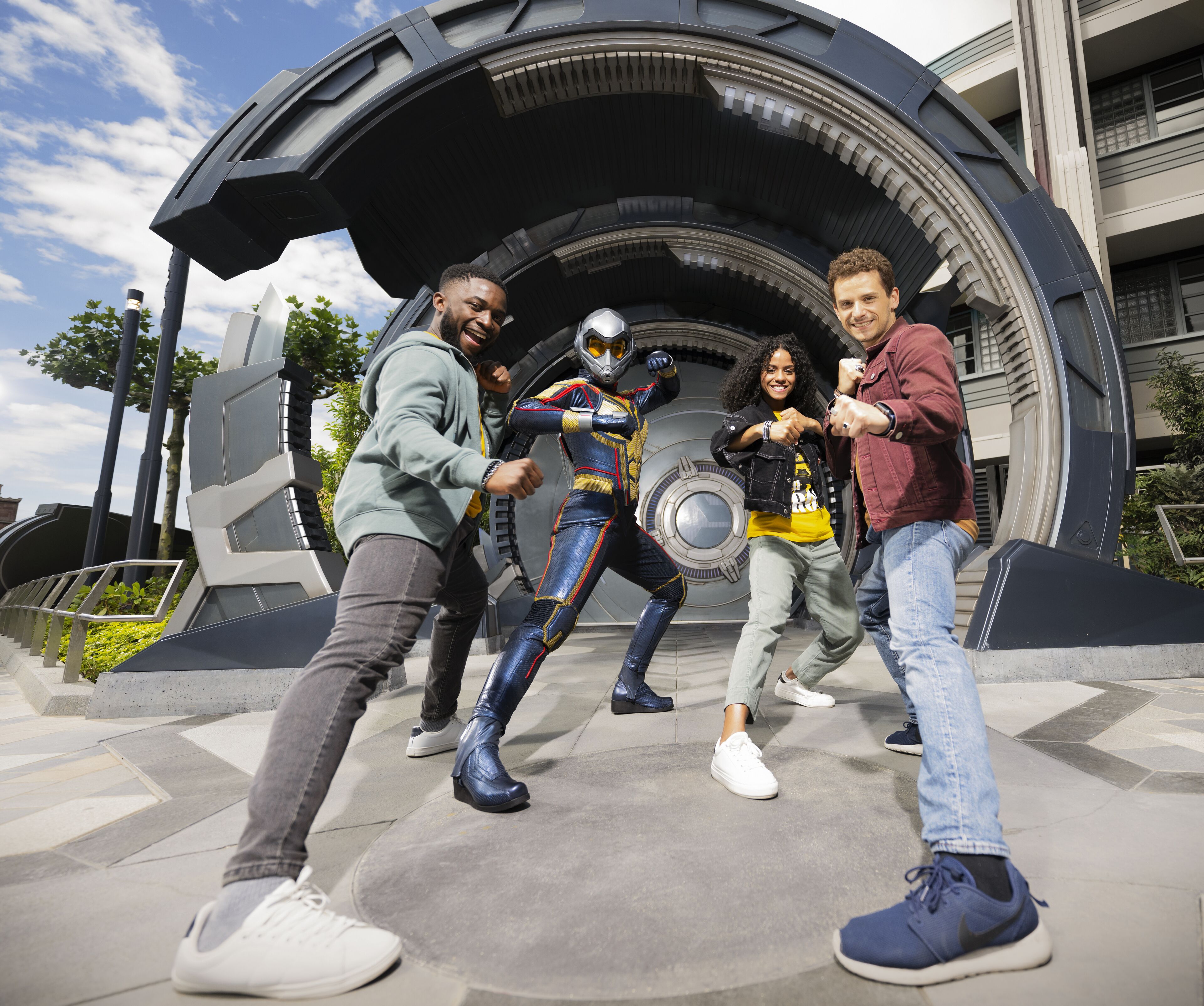 A group of people in front of a futuristic structure with a circular design.