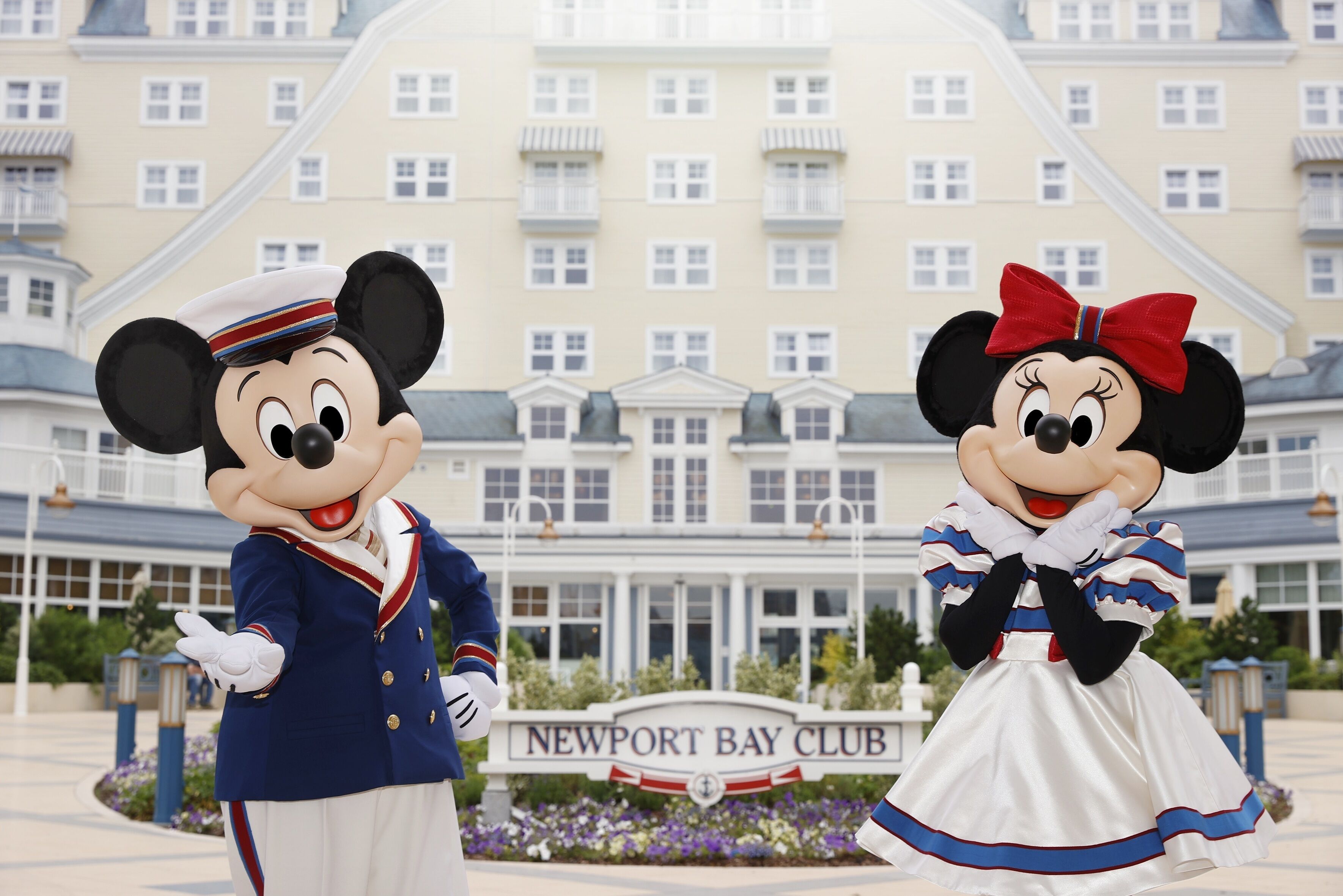 Mickey and Minnie Mouse in front of the Newport Bay Club hotel.