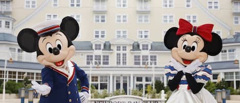 Mickey and Minnie Mouse in front of the Newport Bay Club hotel.