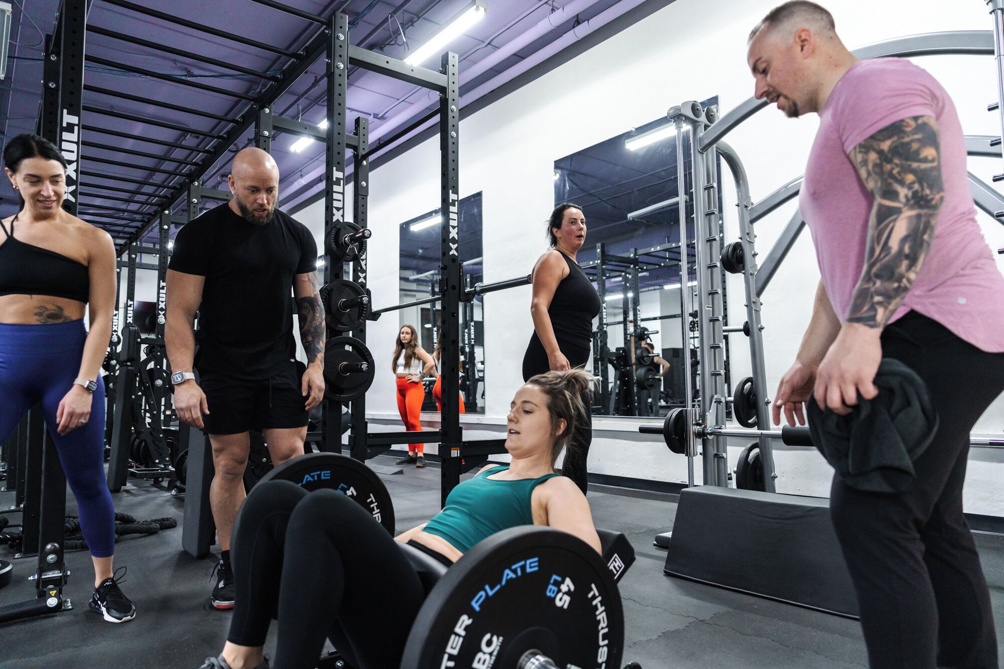 A gym with weightlifting equipment, including barbells and plates.