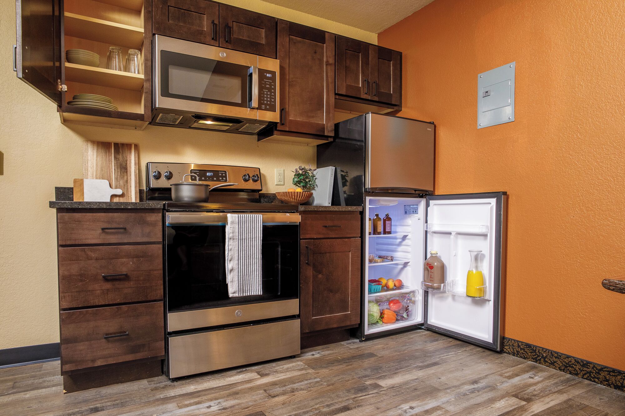 A compact kitchen with a microwave, oven, and refrigerator.