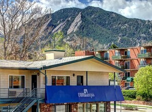 A building with a blue awning labeled 'University Inn' and a mountain backdrop.