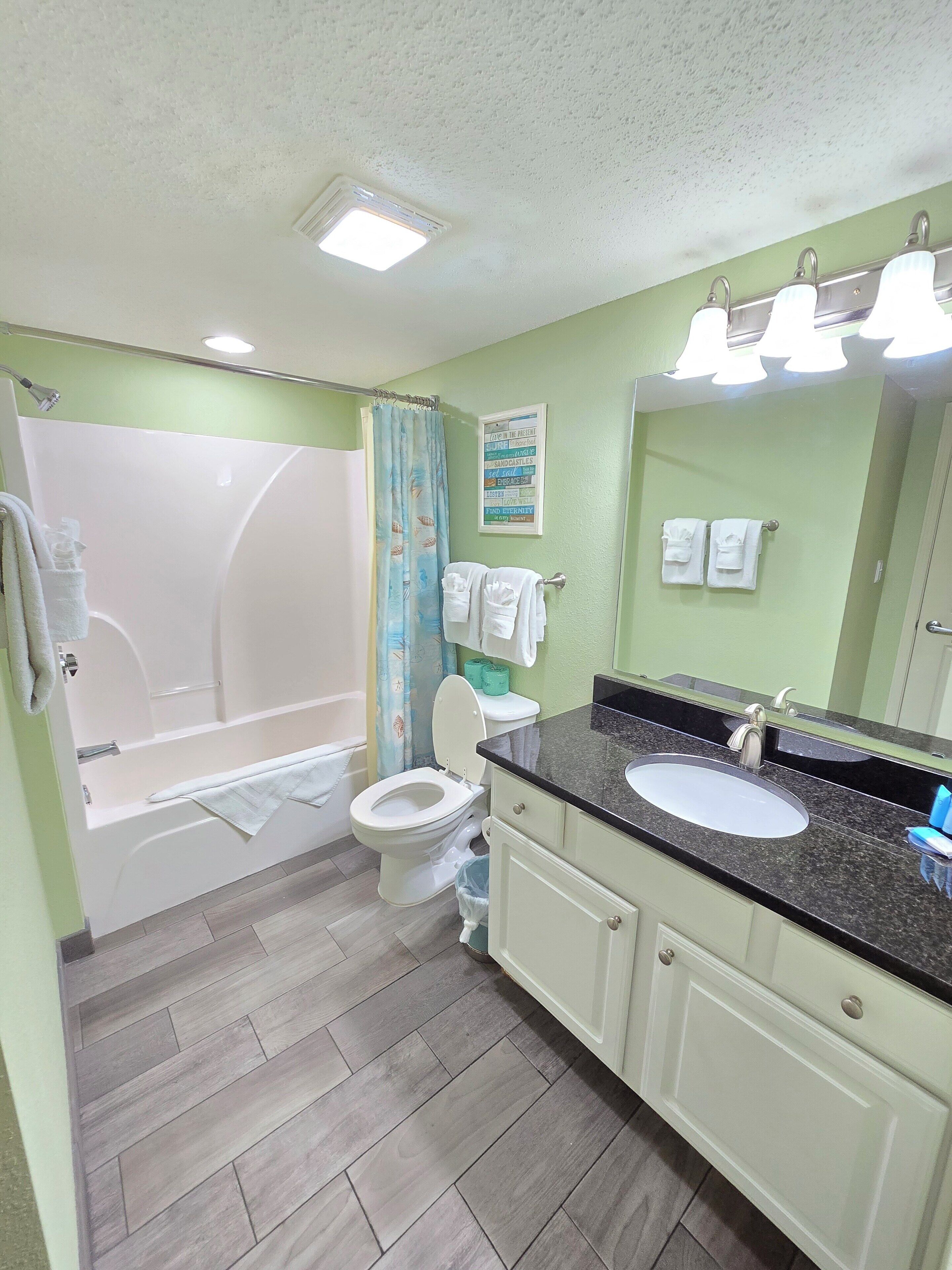 A bathroom with a bathtub, toilet, and sink.