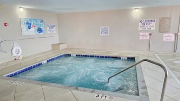 A small indoor pool with a 3-foot depth limit, surrounded by tiled flooring and walls with safety signs.