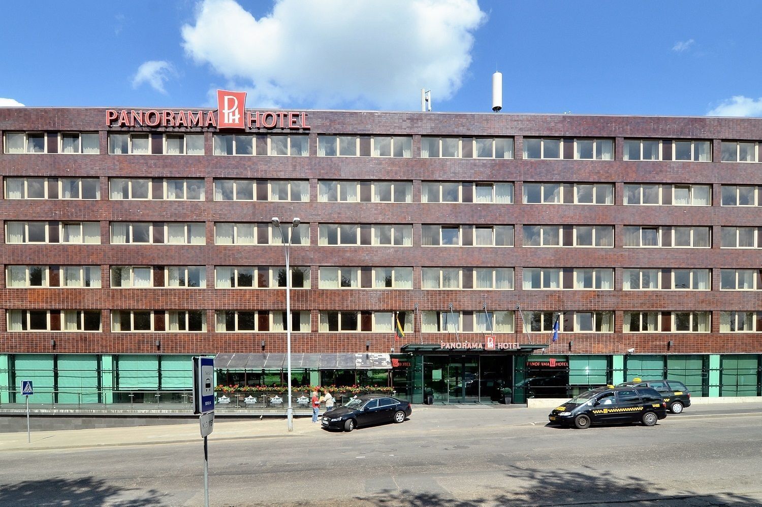 Un hotel a più piani con un cartello ben visibile che riporta la scritta "PANORAMA HOTEL".