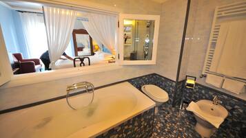 A bathroom with a bathtub, toilet, and bidet.