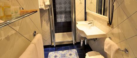 A bathroom with a shower, a sink, and a toilet.