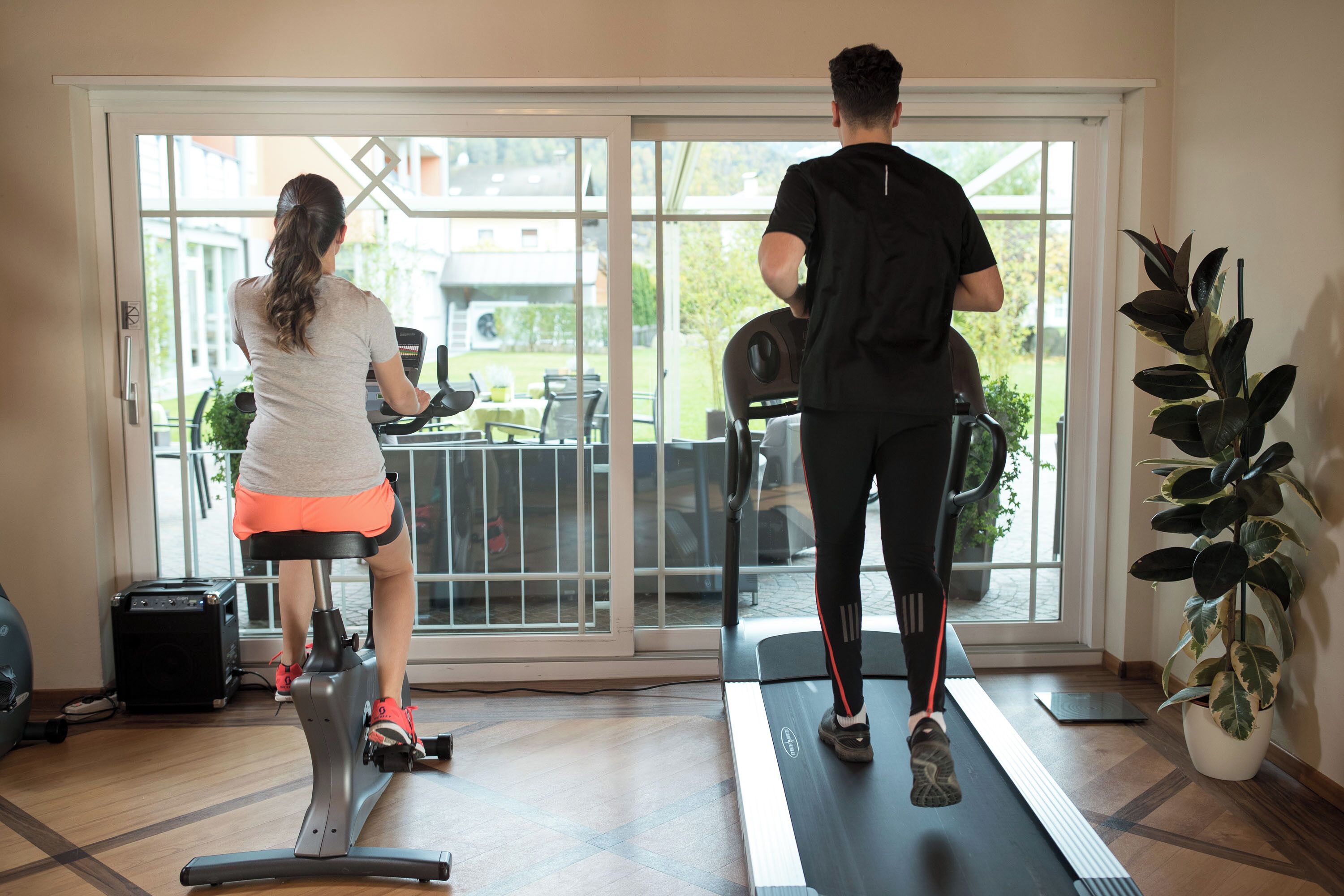 Une pièce équipée d’un tapis de course, d’un vélo elliptique et d’un vélo d’appartement.
