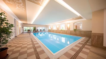 Una piscina techada, sillones reclinables de piscina