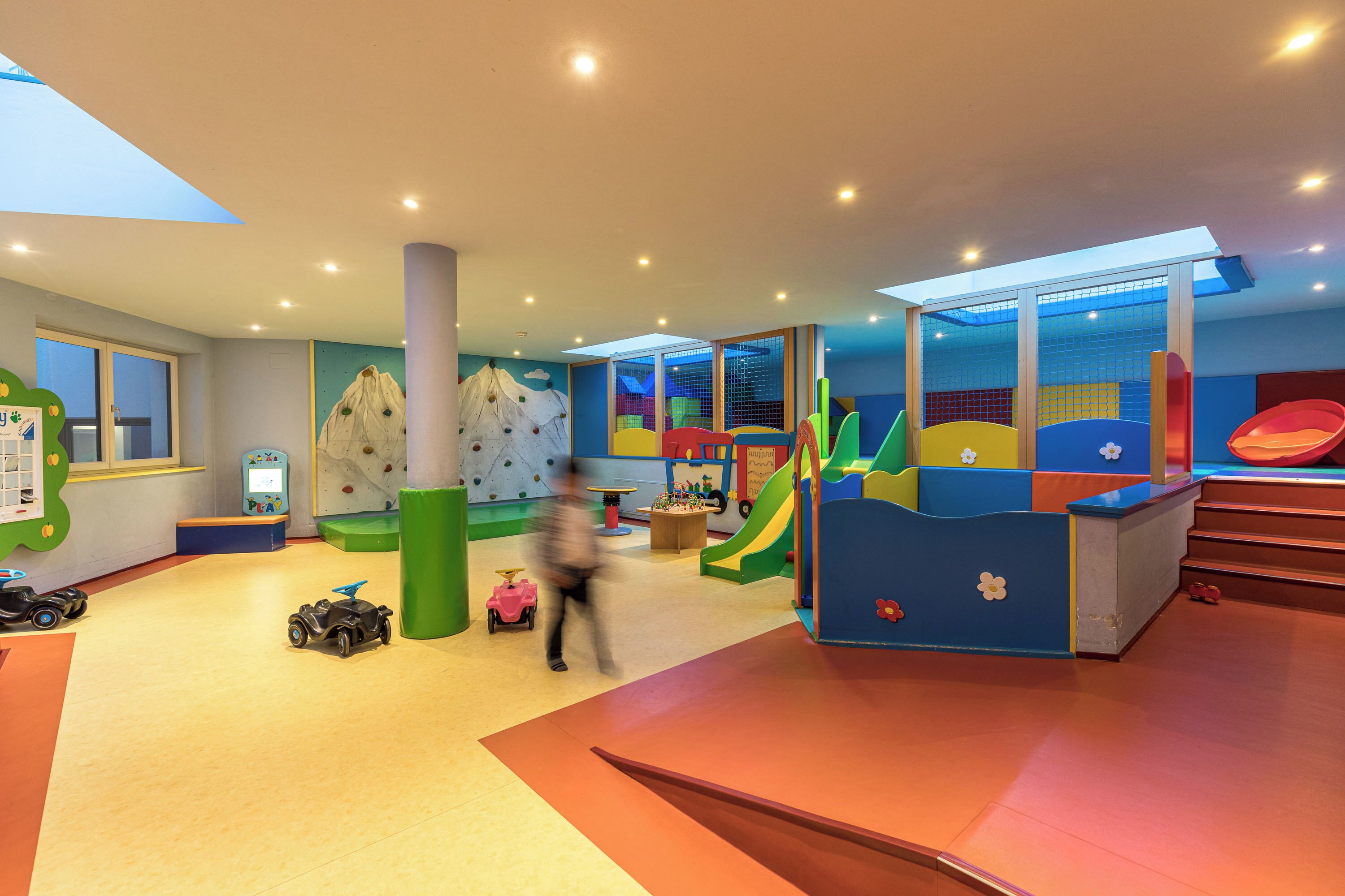 Un área de juegos infantiles con paredes de escalar, toboganes y diversas estructuras recreativas.