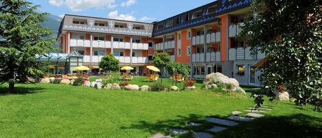 Un hotel con patio, mobiliario exterior y vistas a la montaña.