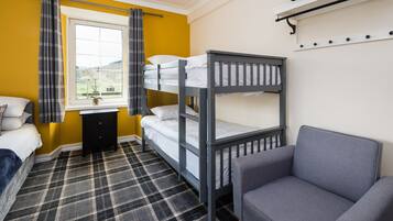 A bunk bed room with a checkered floor, a desk, and a chair.