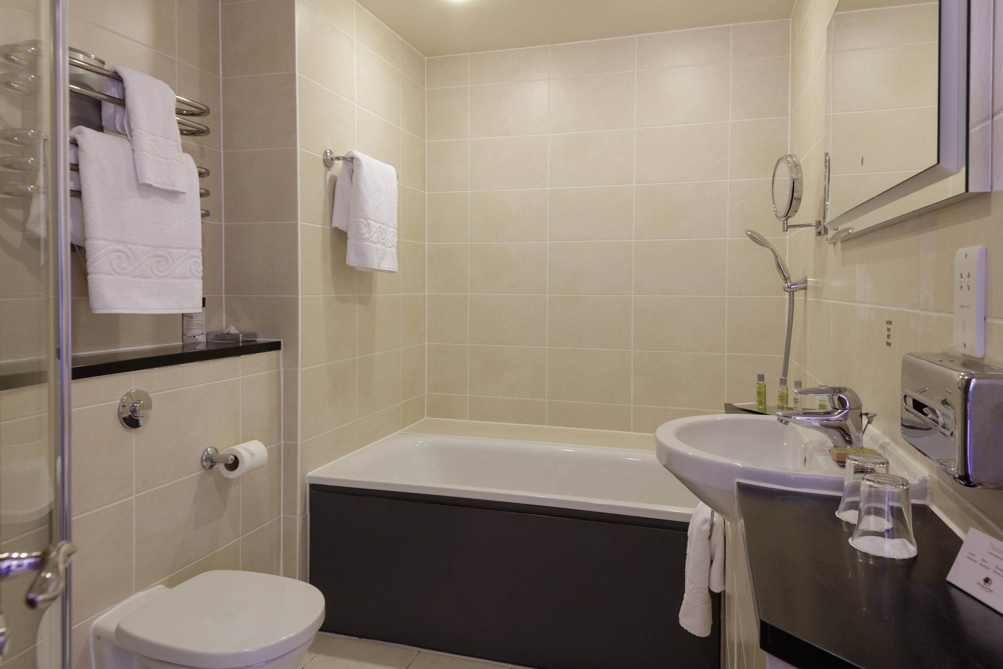 Un baño moderno con bañera, inodoro y lavamanos.