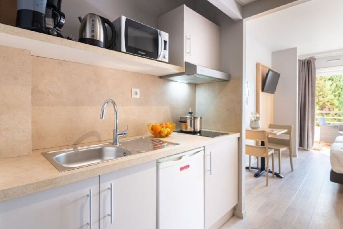 A modern kitchen with a sink, microwave, and cabinets.