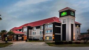 A hotel with a prominent tower, multiple balconies, and a covered entrance.